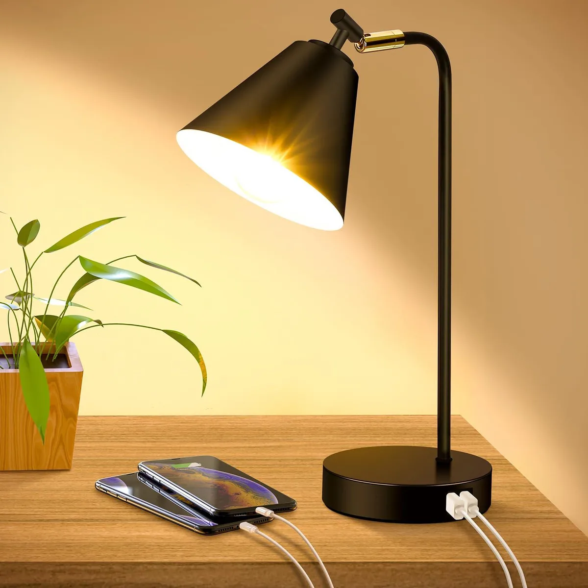Black metal table lamp with adjustable head, USB ports and AC outlet on base