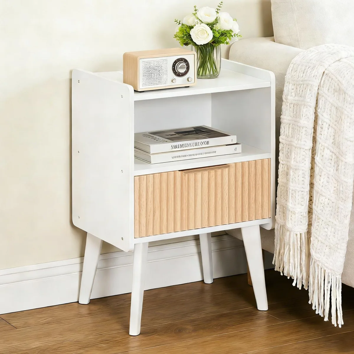 White fluted nightstand with drawer, open shelf, tapered wood legs, gold handles