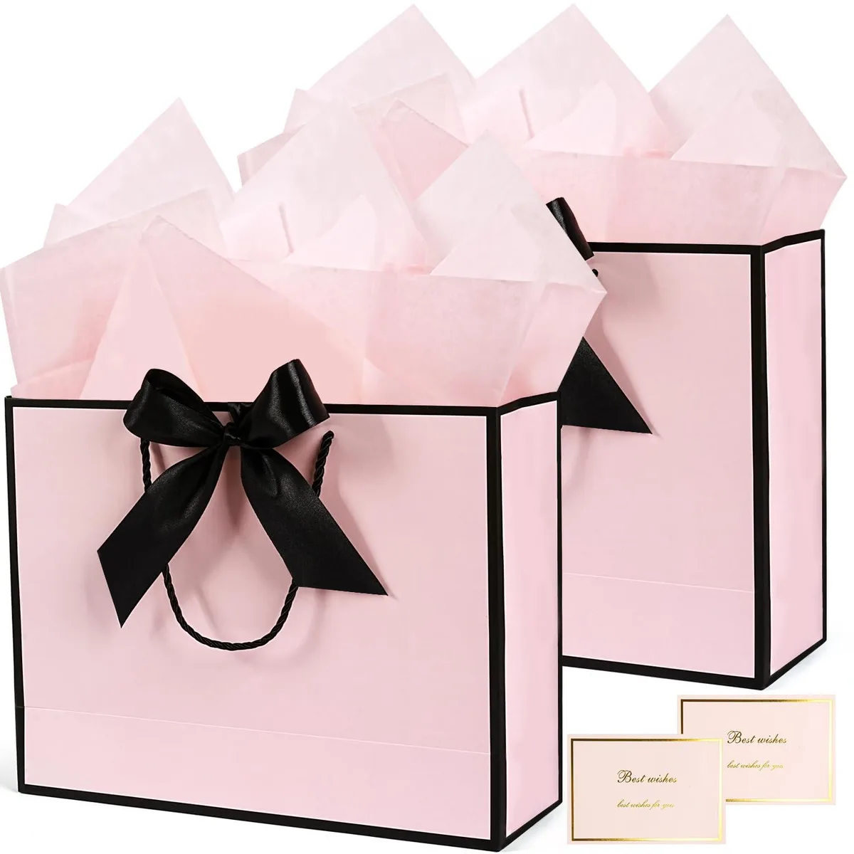 Two large pink paper gift bags with black handles and bow ribbons, plus tissue paper and greeting cards
