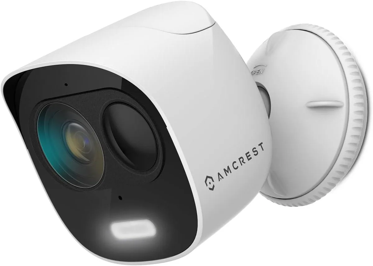 White bullet-style outdoor security camera with integrated spotlight and speaker grille