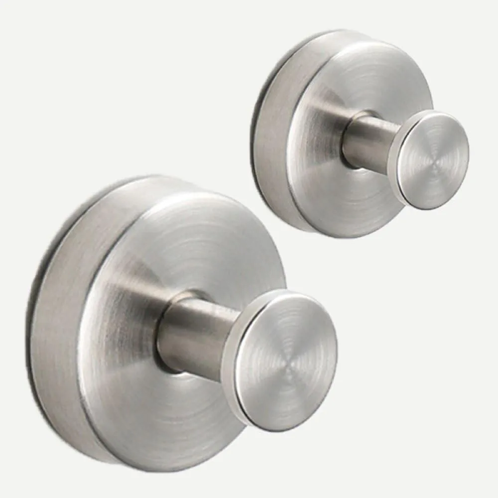 Two stainless steel suction cup hooks with disc tips on a smooth surface