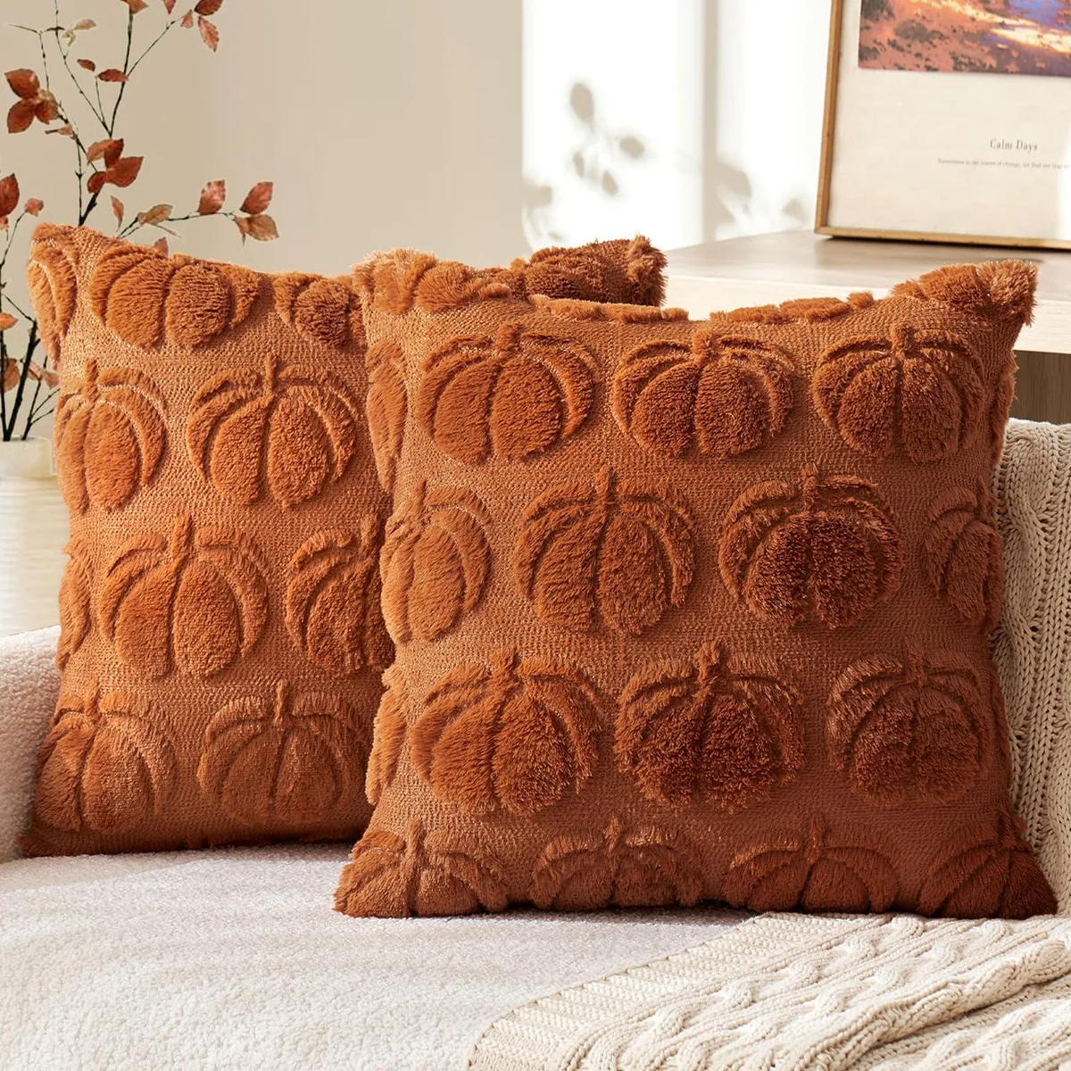 Two square dark rust polyester pillow covers with pumpkin motif, 18 by 18 inches