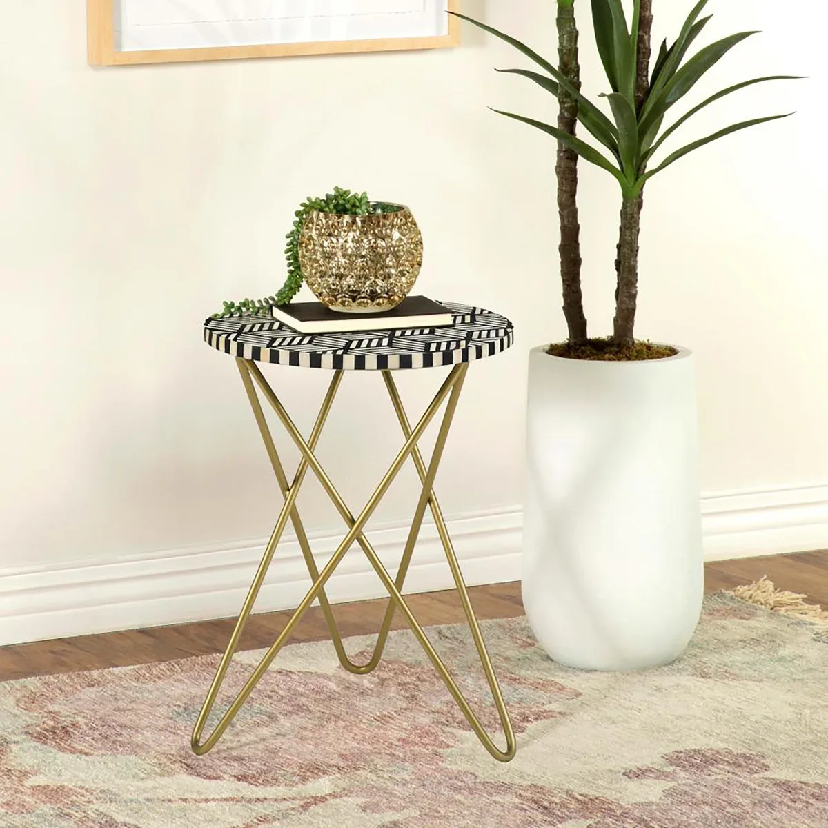 Round mosaic tabletop in white bone and black resin on gold hairpin tripod base