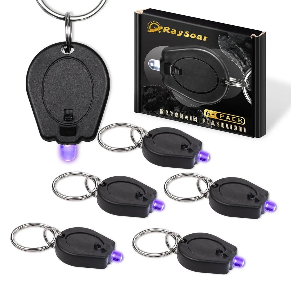 Six tiny black plastic UV keychain lights with slide switches and pinch-to-light middles